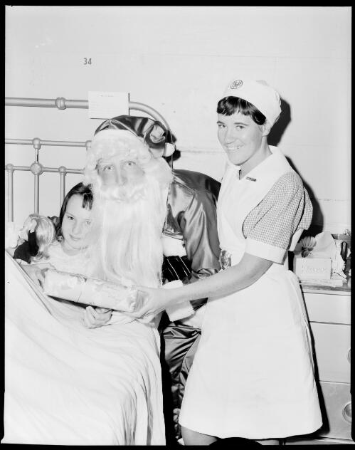 Santa with a child and nurse in the pediatric ward at St. Vincent's General Hospital, Sydney, 13 December, 1967 [2] [picture] / John Mulligan