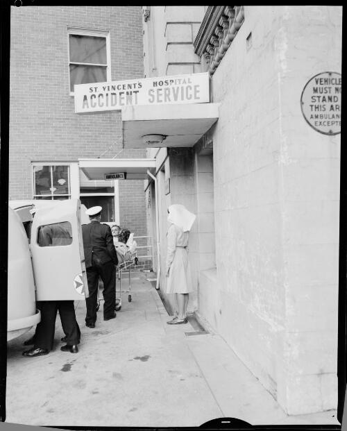 Paramedics unloading a patient out of an ambulance with a nurse outside St. Vincent's General Hospital's emergency room, Sydney, 4 September, 1963 [picture] / John Mulligan