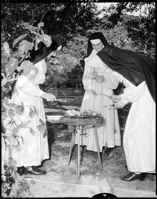Nuns of the order of Sisters of the Good Shepherd cooking food on a barbecue, 28 October, 1963 [2] [picture]/ John Mulligan