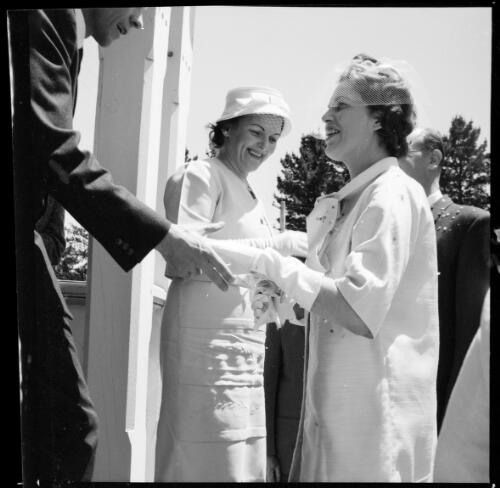 The bride shaking hands with an unidentified man on the steps of the portico of the Christ Church Anglican church during the Val Westmacott wedding, Bong Bong, Southern Highlands, New South Wales, 2 November, 1962 [picture] / John Mulligan