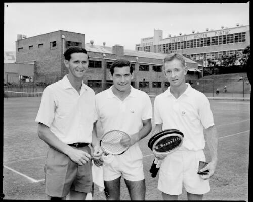 From right to left, Roy Emerson, Boro Jovanovic, and Rod Laver holding tennis rackets at the White City Tennis Courts, Sydney, 2 May, 1962 [picture] / John Mulligan