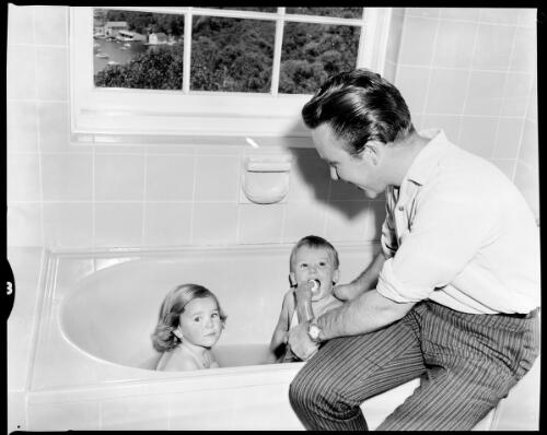 Johnny O'Keefe bathing his children, Victoria and Johnny Jnr, in a promotional shoot for his television comeback, Castlecrag, Sydney, 6 November, 1962 [picture] / John Mulligan