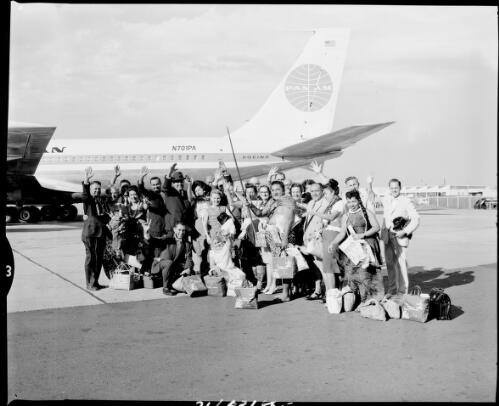 Passengers in front of the Pan Am plane N701PA used for the inaugural Pan Am flight from American Samoa to Sydney, Mascot Airport, 1 December, 1962 [picture] / John Mulligan