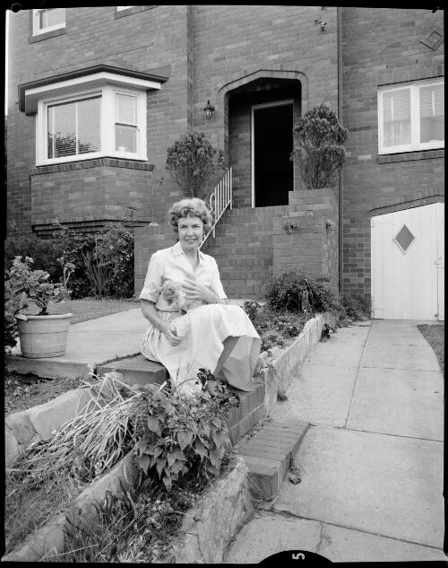 Ruth Park holding her cat outside her home in Balgowlah, Sydney, 10 December, 1962 [picture] / John Mulligan