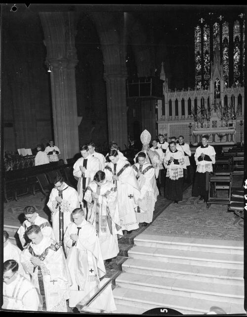 Newly ordained priests walking down the steps from the altar after their ordination during first mass at St. Mary's Cathedral, Sydney, 19 July, 1963 [picture] / John Mulligan