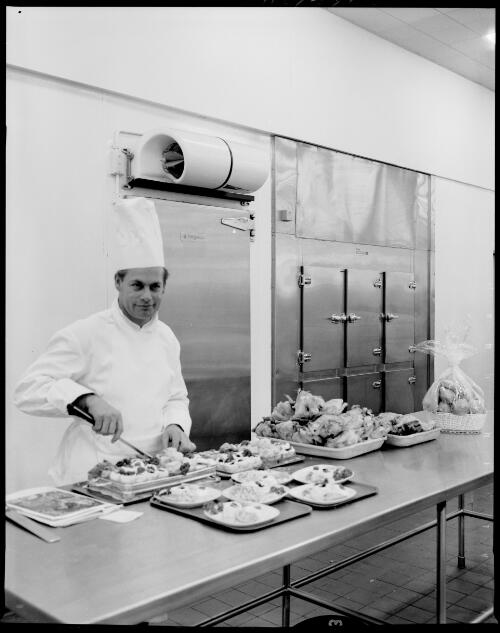 An unidentified chef preparing meals in front of the cold storage refrigeration unit at the Ansett Flight Catering Centre, Mascot Airport, 15 July, 1968 [picture] / John Mulligan
