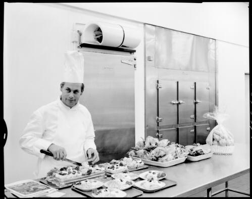 Close up of an unidentified chef preparing meals in front of the cold storage refrigeration unit at the Ansett Flight Catering Centre, Mascot Airport, 15 July, 1968 [picture] / John Mulligan