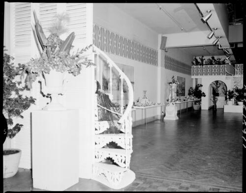 Close up of a decorative staircase at the Farmers' Blaxland Gallery with camellias on show in the background, Sydney, 29 July, 1968 [picture] / John Mulligan