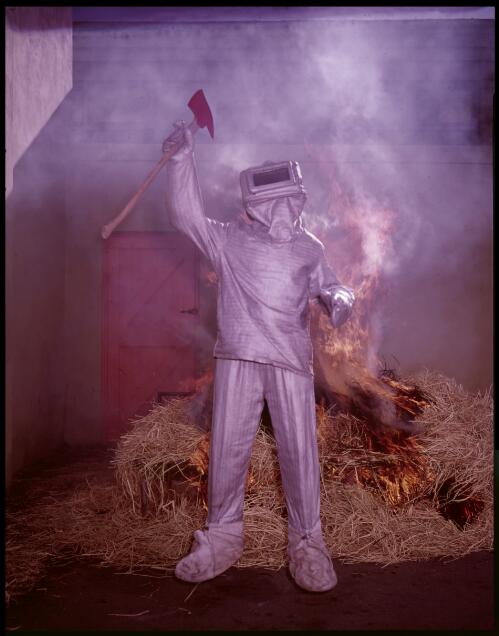 A New South Wales Fire Brigade fireman in full protective clothing during training, Sydney, 25 June, 1962 [transparency] / John Mulligan