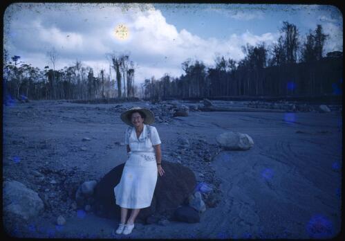 Sister Gilbert at the Andemba River, sitting on a large rock deposited by the volcano, Papua New Guinea, 1951 [transparency] / Albert Speer