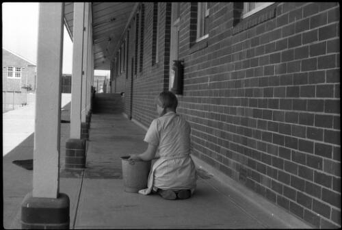 Prisoner on knees scrubbing verandah floor, State Reformatory for Women, Long Bay, Sydney [2] [picture] / John Mulligan