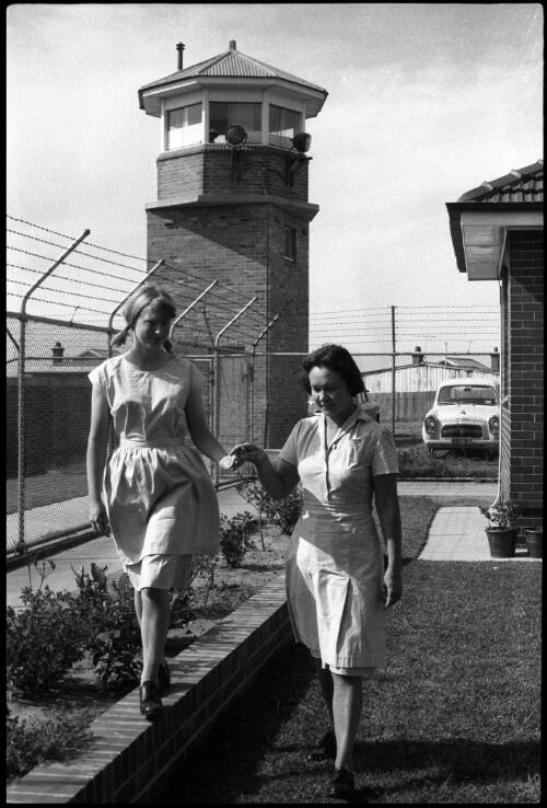 Two prisoners walking in garden under tower, State Reformatory for Women, Long Bay, Sydney [2] [picture] / John Mulligan