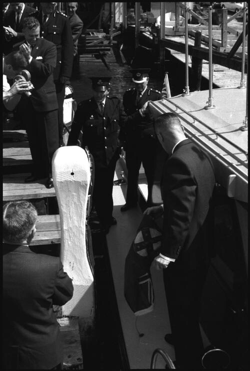 Unidentified man removing flag from new police launch Nemesis which will be used to combat drug trafficking, Sydney Harbour, 6 June 1966 [3] [picture] / John Mulligan