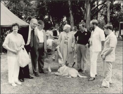 [Governor-General Sir Ninian Stephen (2nd from left) standing with a group of people around a labrador dog, ca. 1985] [picture] / The Canberra Times