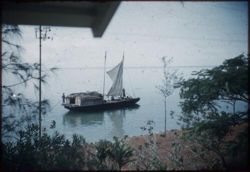 A house-boat, with a sail, is passing along Port Moresby, Papua New Guinea, 1953 [picture] / Terence and Margaret Spencer