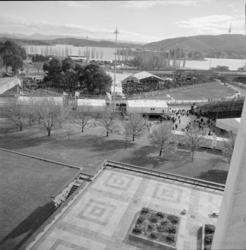 [Car race, panoramic view of part of the track taken from the National Library of Australia, with GMC overpass to right of picture, Impulse Airlines sign on fence in front of Ford and Holden tents, Lake Burley Griffin in distance, GMC 400 V8 Supercar Series 2000, Canberra, 9-11 June, 2000] [picture] / Loui Seselja