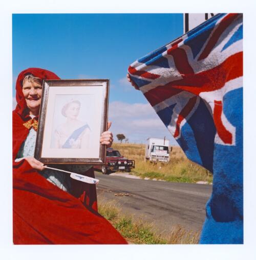 [2 people wait outside Kryal Castle on the outskirts of Ballarat to greet the Queen, Western Freeway, Friday 24th March 2000] [picture] / Matthew Sleeth