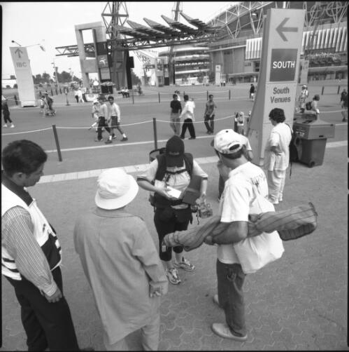 [Spectators buy Kodak film from a vendor], Sydney Olympic Park, 21 September 2000 [picture] / Loui Seselja