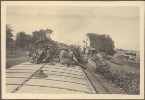 Passing [railway] station near Cairo, [as viewed from top of train carriage where some soldiers of the 8th Light Horse Regiment travelled during the journey from Suez to Cairo, April 4, 1915] [picture] / J.P. Campbell