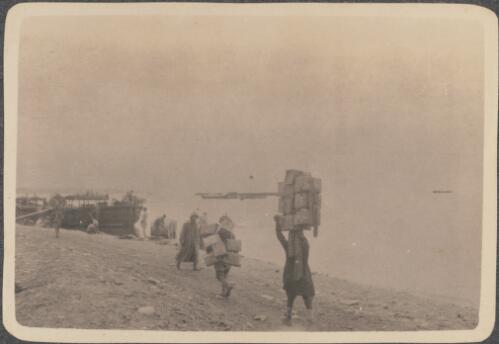 Beach scene [at Anzac Cove, soldiers carrying packs along the edge of the beach for loading on a pinnace, May? 1915] [picture] / J.P. Campbell