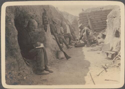 Writing in the trenches, [Anzac soldiers sit in their shelters in the trench and write letters home, June? 1915] [picture] / J.P. Campbell