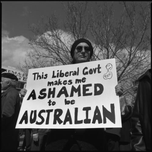 [Demonstrator with banner expressing shame to be Australian over the Federal Liberal Party's policy and treatment of refugees, Garema Place, Civic, Canberra on Aug. 31, 2001] [picture] / Loui Seselja