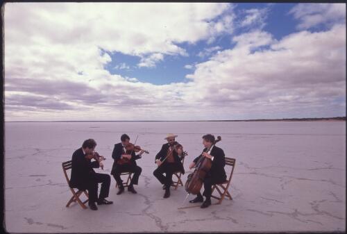 The Australian String Quartet members, (left to right) Peter Tanfield, James Cuddeford, Keith Crellin and Niall Brown, out on the blinding white salt plains of Lake Hart for a filming of a dream sequence which was part of an ABC documentary of their 1999 tour of outback South Australia [picture] / Ian Kenins