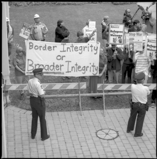 [Demonstators outside the National Press Club, Canberra, with placards reading "Border integrity or broader integrity", "Socialist Alliance, Refugees are welcome", "Stop war", 8 November 2001] [picture] / Loui Seselja
