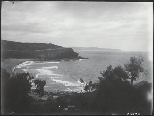 A beach and cliff seen through a gap in the trees on a hill, Bathurst Island, Northern Territory