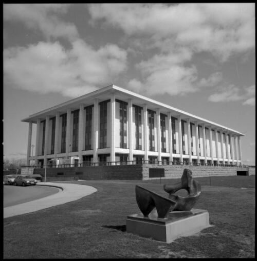 "Two piece reclining figure no. 9" by Henry Moore (1969) with National Library of Australia, Canberra, in background, 9 September 1986 [picture] / National Library of Australia staff photographer