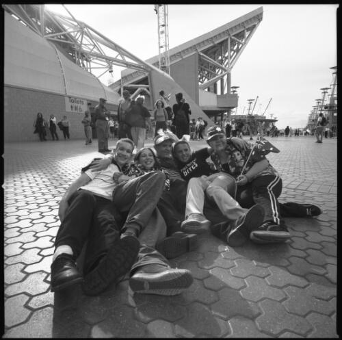 [Five Australian fans lying on the ground in front of Olympic Stadium, Sydney 2000 Paralympic Games, 22 October 2000] [picture] / Louis Seselja