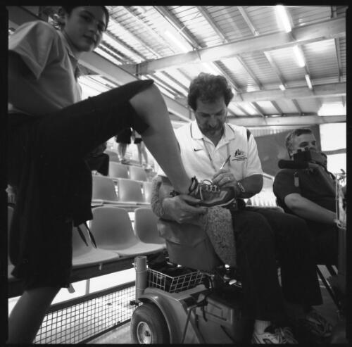 Shooter Jim Nomarhas signs a fan's shoe, Sydney International Shooting Centre, Liverpool, 2000 Paralympic Games, 22 October 2000 [picture] / Louis Seselja