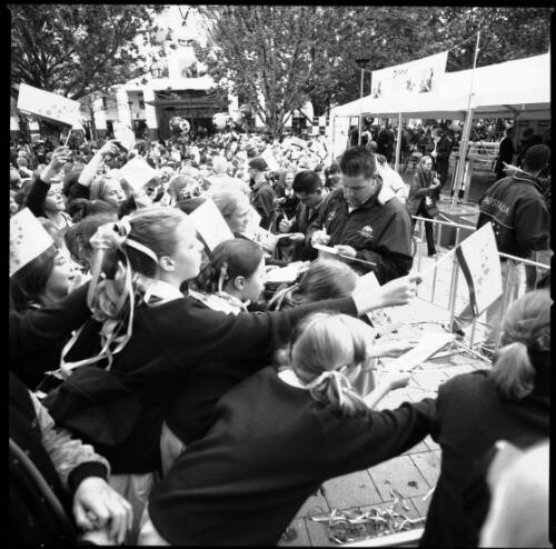 [Australian Paralympians signing autographs in Garema Place with Garema Court in the background, Canberra, 2 November 2000] [picture] / Louis Seselja