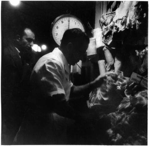 R. H. Gibson, butcher, meat market stall, Queen Victoria Markets, Melbourne, 1956 [picture] / Jeff Carter