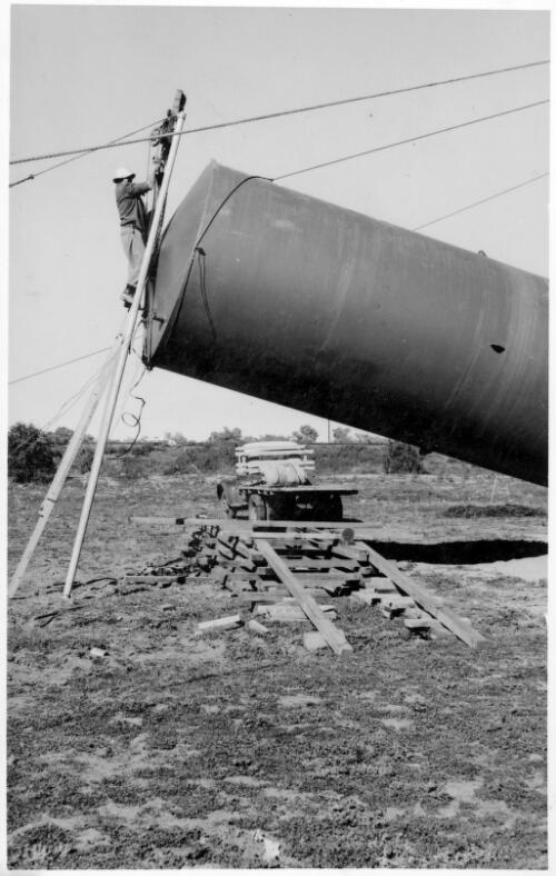 Unidentifed man working on a storage tank during the construction of the Bourke depot [picture]