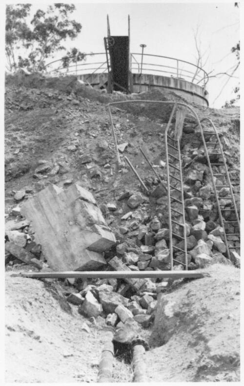 View showing damage to the no.1 storage tank enclosure wall at the Cootamundra Depot during a landslide, November, 1955 [picture]