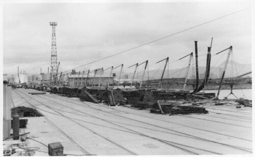 View of the methold used to install an underwater pipeline using a series of small cranes at the no.6 jetty at the Port Kembla shipping terminal, 21 March, 1959 [picture]