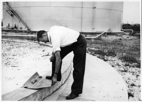 The maintenance engineer, B. Taylor, examining the blueprints for the construction of the second bulk tank (B2) at the Birkenhead shipping termianl, August, 1952 [picture]