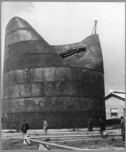 View of Tank B2 caved in after an overnight storm and employees examining the damage at the Birkenhead shipping terminal, 9 September, 1952 [picture]