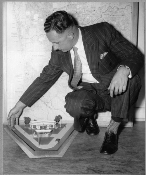 Mr. A. Hollings, Superintendent Marketing Development, demonstrating to Merchandisers the advantages of the new modern service station layouts in front of a map of Adelaide, April, 1953 [picture]