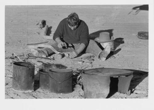 Drover Len Cant punching hobble straps on the Birdsville Track, 1963 [picture] / Jeff Carter