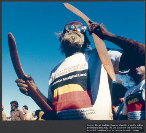 Tommy Wongi, traditional owner, about to show the skill of boomerang throwing; the top surface of the boomerang in his left hand has been incised partly as decoration [picture] / prepared by Media and Communications, Department of Aboriginal Affairs