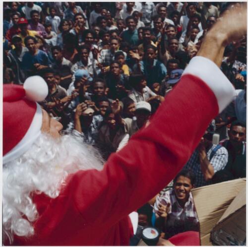 INTERFET Santa Claus (an Italian soldier) throws toys from on top of a jeep to a crowd of locals, Dili, East Timor, 25 December 1999 [picture] / Matthew Sleeth