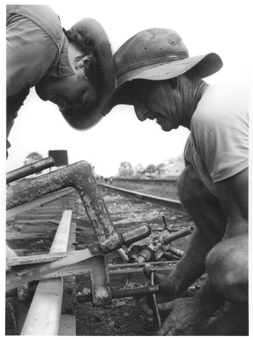 Two workmen repairing railway track, Cardwell, Queensland, 1972 [picture] / Raymond de Berquelle