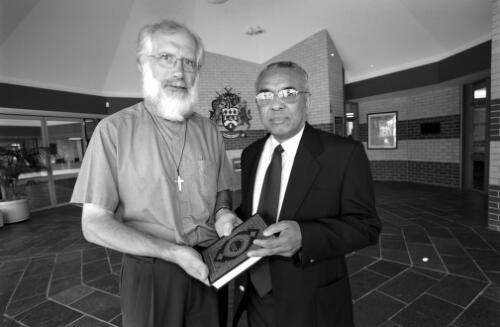 The President of AFIC, Dr Ameer Ali (r) presents the Koran to the Anglican Archdeacon of the Upper Hunter, the Revd Ian Palmer, in the foyer of Muswellbrook Civic Centre, prior to the Salatul Istisqa, the Islamic rain prayer, 19 January 2003 [picture] / Paul Cosgrave