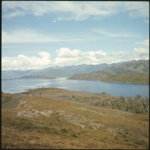 Lake Pedder partly filled, looking down grassy ridge with four wheel drive track, Tasmania, ca. 1973, 2 [transparency] / Russ Ashton