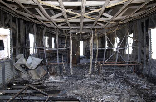 Interior of accommodation unit destroyed by fire at Mike Compound, Woomera Detention Centre, 8 January, 2003 [2] [picture] / Damian McDonald