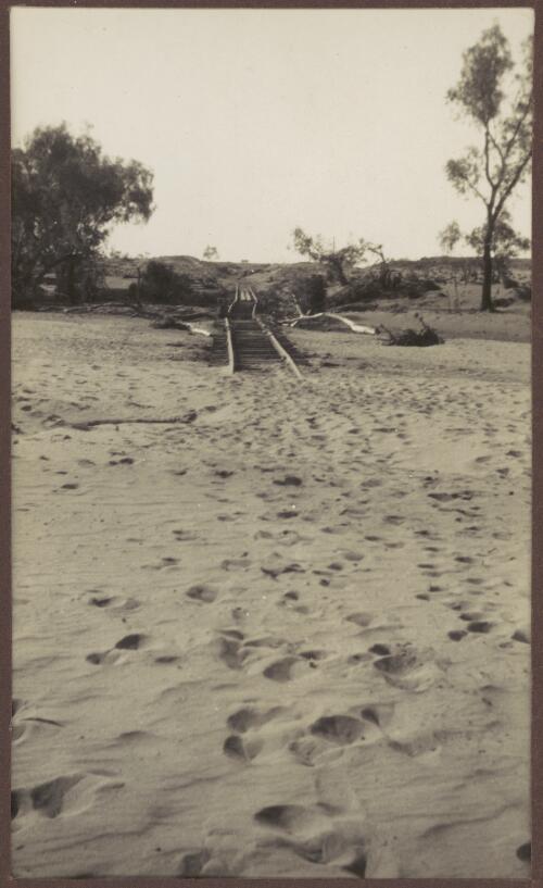 Twisted railway line covered with silt, Northern Territory, 1939 [picture] / Clarence Bernhardt
