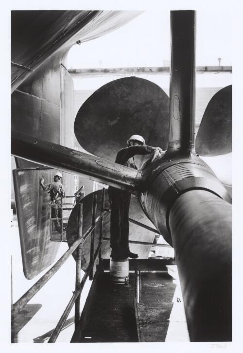 An engineer re-greases components in the propeller shaft after refitting of the propeller at the Captain Cook Graving Dock, Garden Island, New South Wales, 2001 [picture] / Jon Reid
