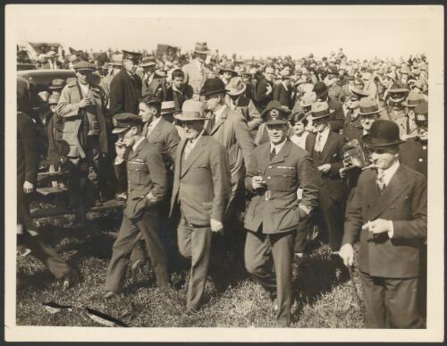 Charles Kingsford Smith and Charles Ulm in RAAF uniform, with Mayor of Auckland, George Baildon, walking through crowd after landing at Auckland, New Zealand, September 1928 [picture]